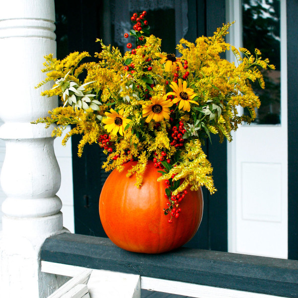 A brilliant pumpkin container and pyracantha berries punctuate an arrangement of autumn “weeds” and lingering garden blossoms.